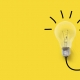 Yellow background with image of a light bulb turned on.
